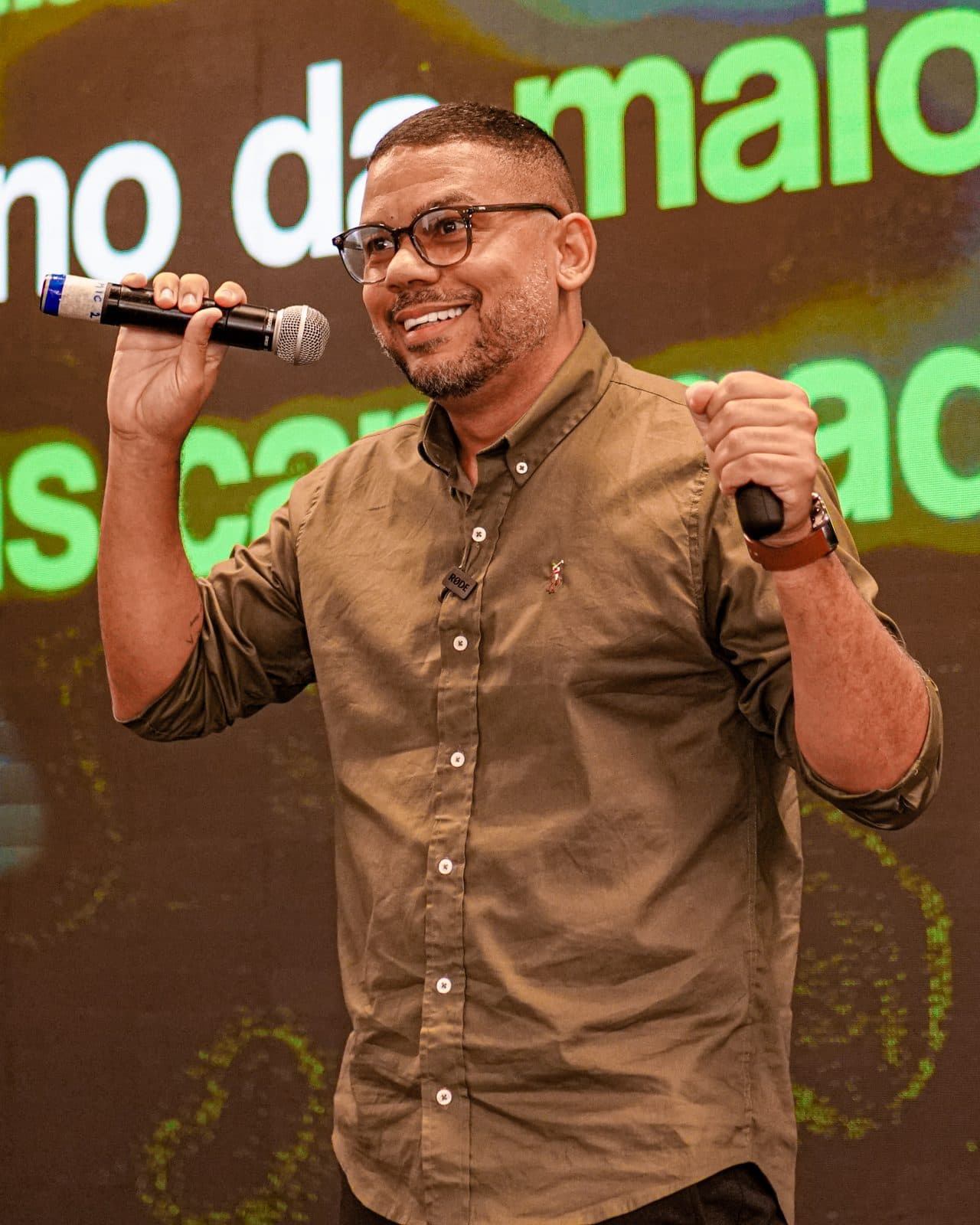 Rafael comemorando no palco com microfone na mão
