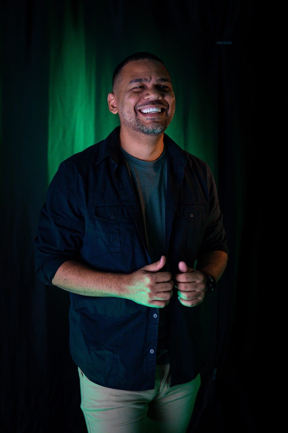 Rafael Soares sorrindo, com luz verde ao fundo